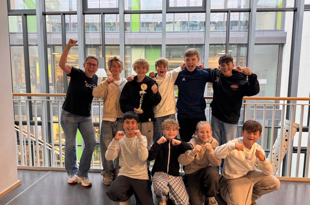 Schulleiterin Frau Amrhein und die erfolgreichen Schüler der Comenius-Realschule jubeln mit dem Siegerpokal für den 3. Platz beim Junior Messe-Cup.